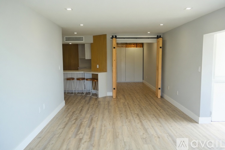 A room with wooden floors and a bar area.