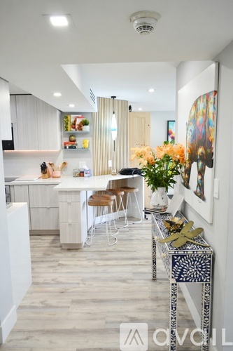 A modern kitchen with white cabinets and a dining table with chairs.