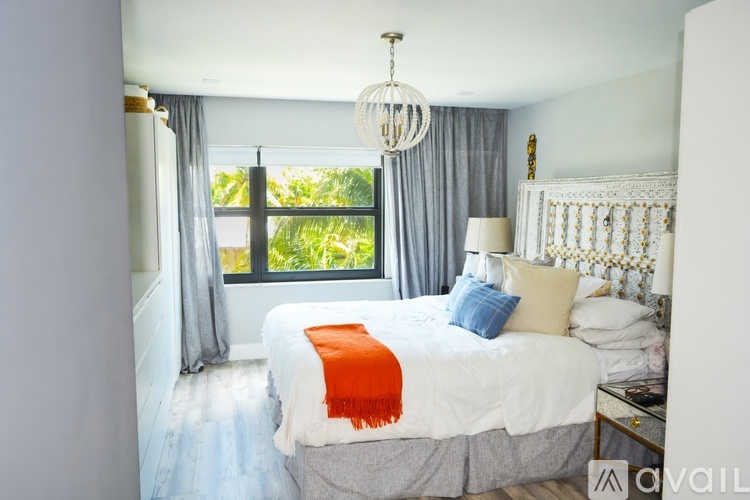 A bedroom with a large bed and a chandelier.