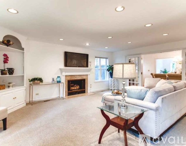 A living room with a fireplace and a white couch.