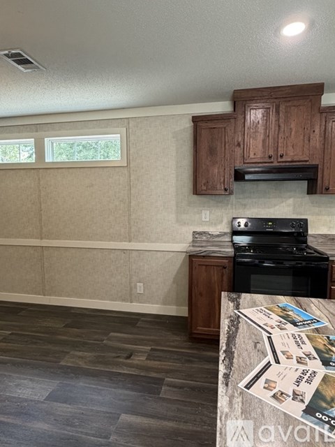 A kitchen with wooden cabinets and a black stove top oven.