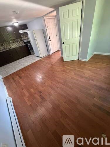 A room with wooden flooring and a white door.