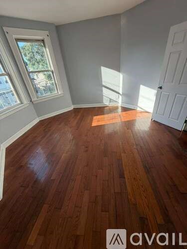 A room with wooden flooring and a white door.