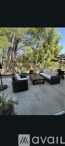 A patio with a table and chairs surrounded by trees.