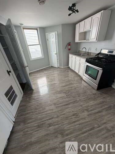 A kitchen with a black stove top oven and white cabinets.