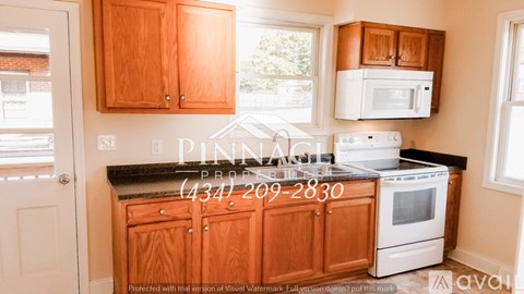 A kitchen with wooden cabinets and a white stove top oven.