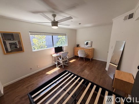 A living room with a striped rug and a ceiling fan.