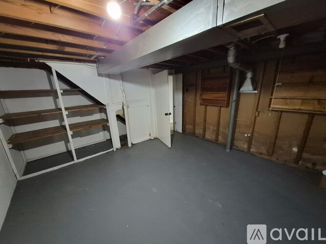 A room with a wooden staircase and a door is available for rent.