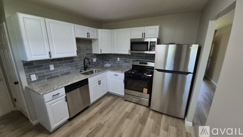 A kitchen with white cabinets and a granite countertop.