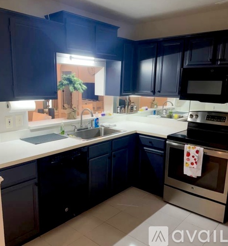 A kitchen with dark blue cabinets and a white countertop.