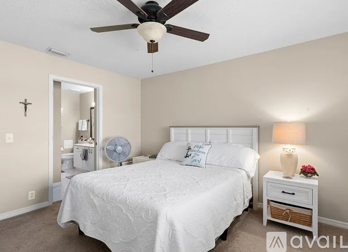 A bedroom with a bed, nightstand, and a ceiling fan.