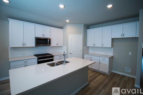 A kitchen with white cabinets and a white countertop.