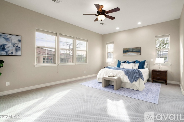 A bedroom with a large bed and a ceiling fan.