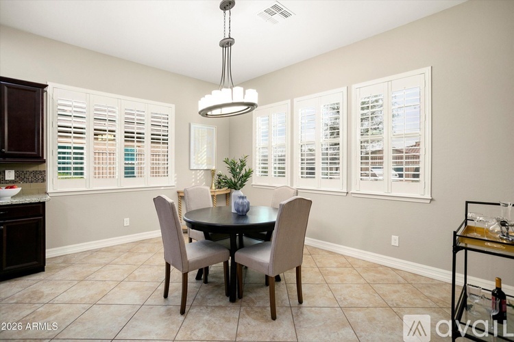 A dining room with a table and chairs.