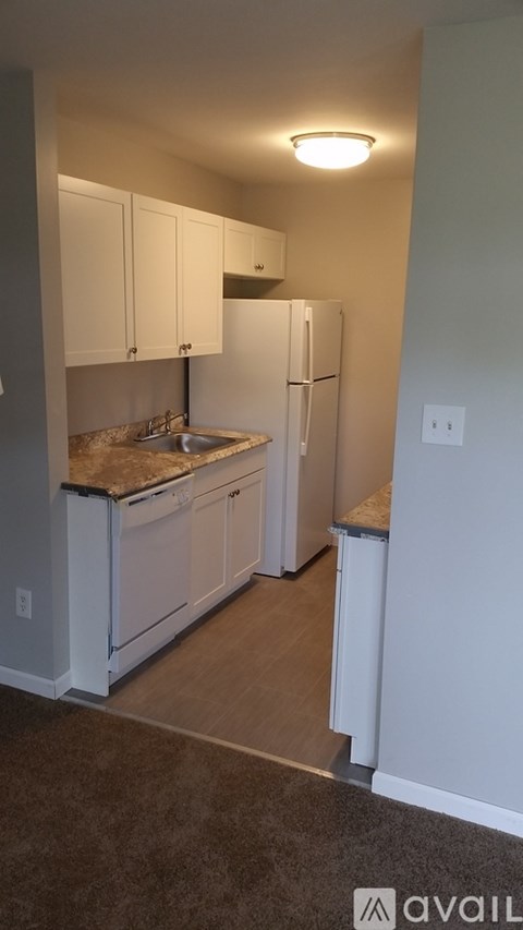 A kitchen with white cabinets and appliances.