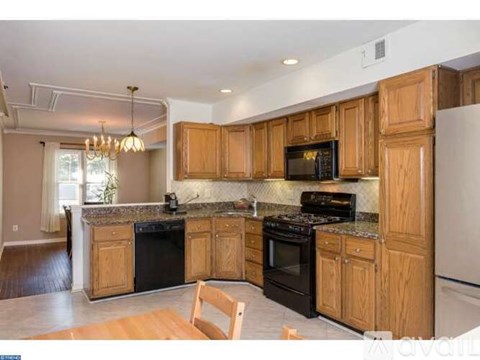 A kitchen with wooden cabinets and black appliances.