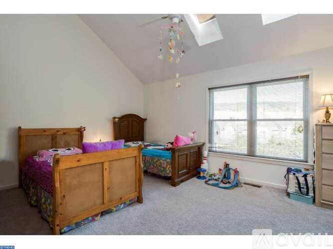 A bedroom with two beds and a window.