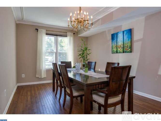 A dining room with a table set for four and a chandelier.