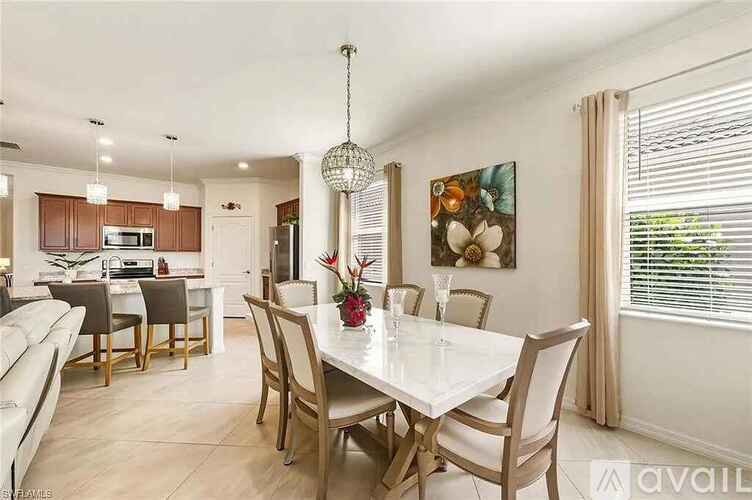 A dining room with a white table and chairs.