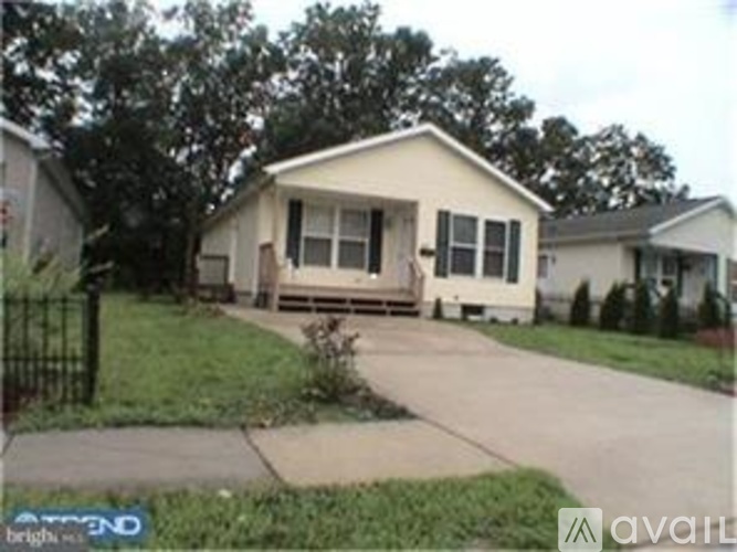 A beige house with a black fence in front.