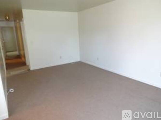 A large empty room with a door on the left side.