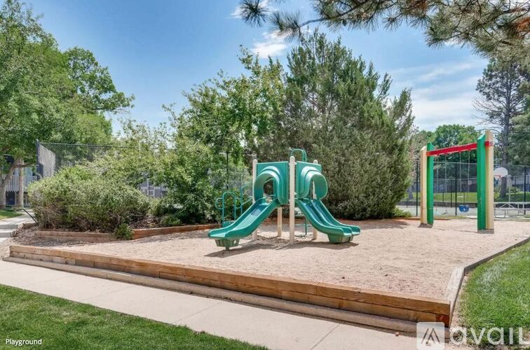 A playground with a green slide and a red structure.