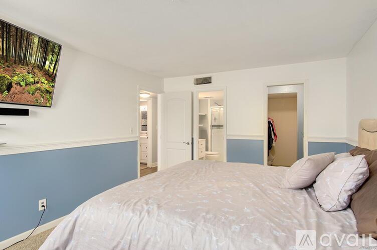 A bedroom with a large bed and a painting on the wall.