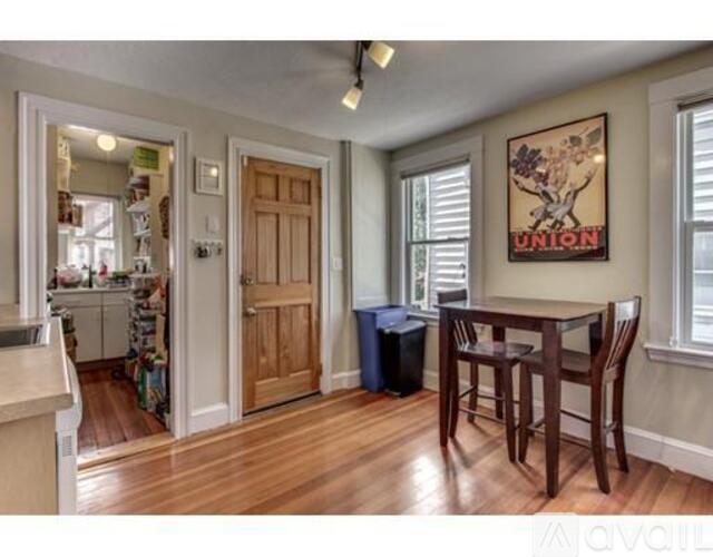 A dining room with a wooden table and chairs.