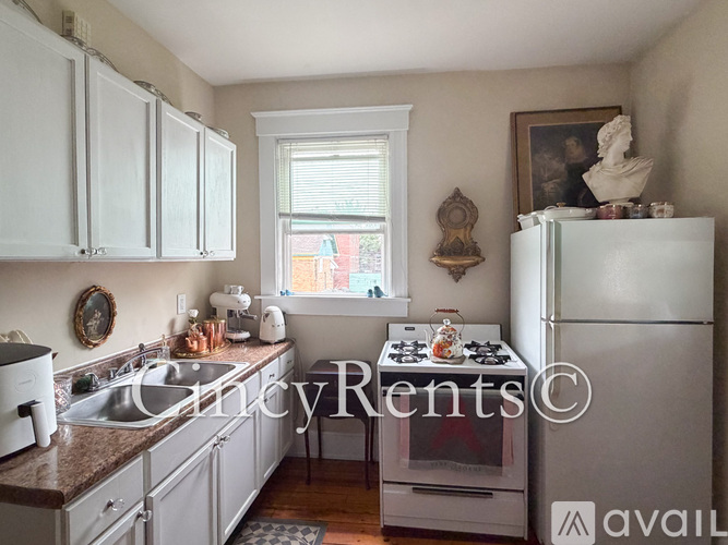 A kitchen with white cabinets and a white fridge.
