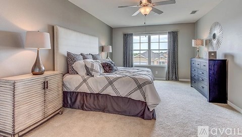 A bedroom with a large bed and a ceiling fan.