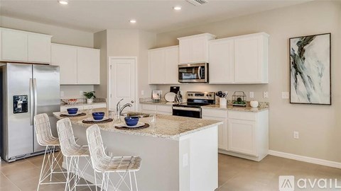 A kitchen with white cabinets and a granite countertop.