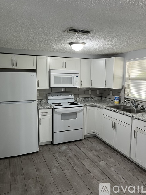 A kitchen with white appliances and cabinets.