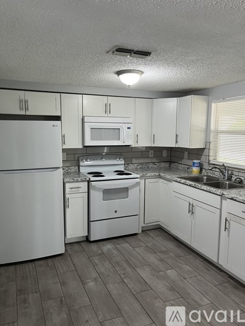 A kitchen with white appliances and cabinets.
