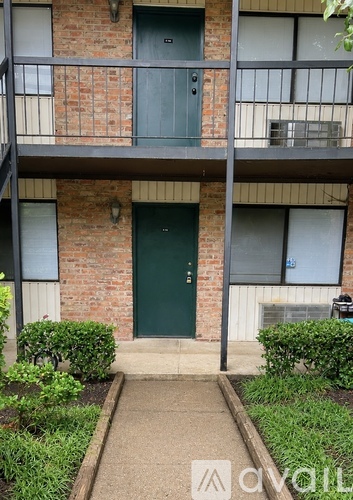 A brick building with a green door and windows.