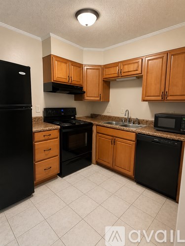 A kitchen with black appliances and wooden cabinets.