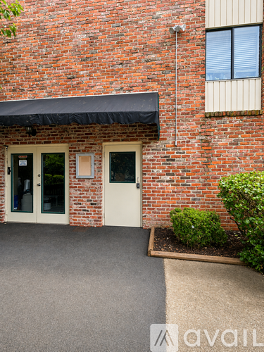 A brick building with a white door and windows.