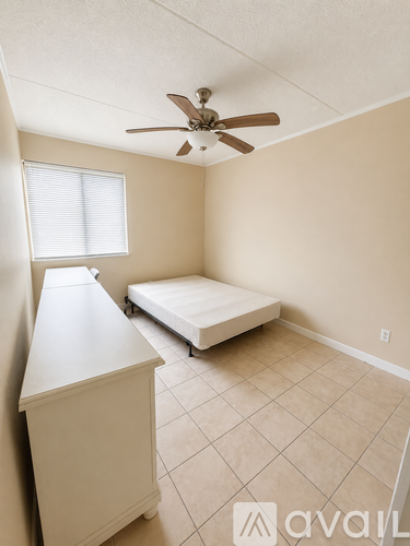 A bedroom with a bed, dresser, and window.