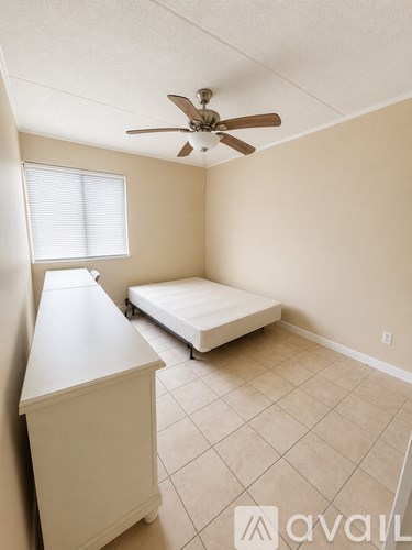 A bedroom with a bed, dresser, and window.