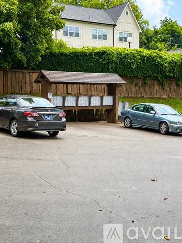 Two cars are parked in a driveway in front of a house.