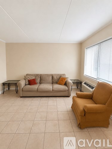 A living room with a couch, chair, and a small table.