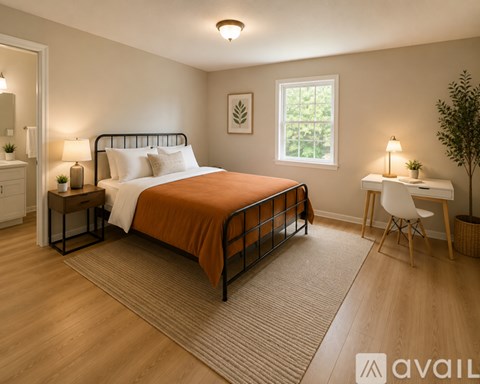 A bedroom with a large bed and a desk with a chair.