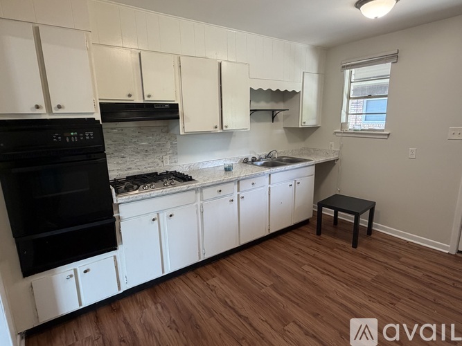 A kitchen with white cabinets and a black oven.