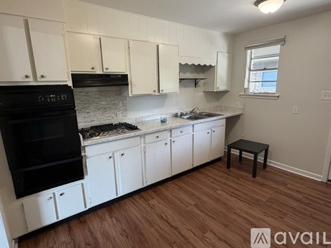A kitchen with white cabinets and a black oven.