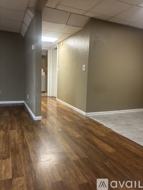 A hallway with wood flooring and white walls.