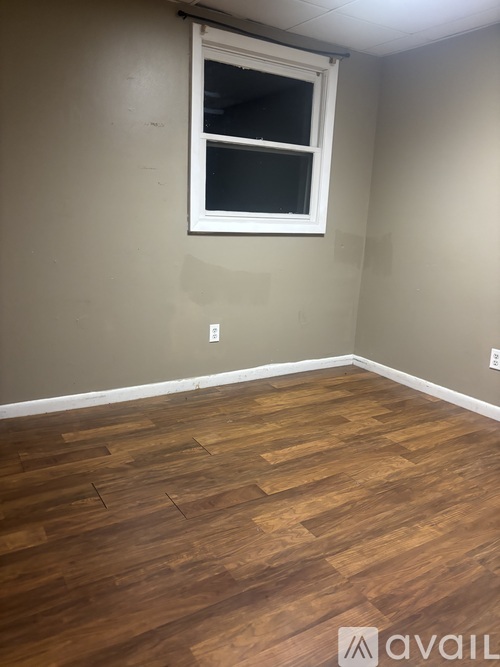 A room with a wooden floor and a window.