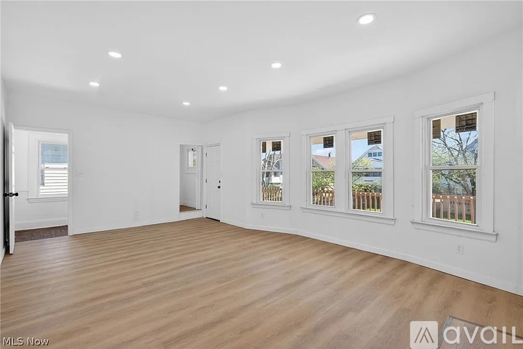 A large empty room with wooden floors and white walls.