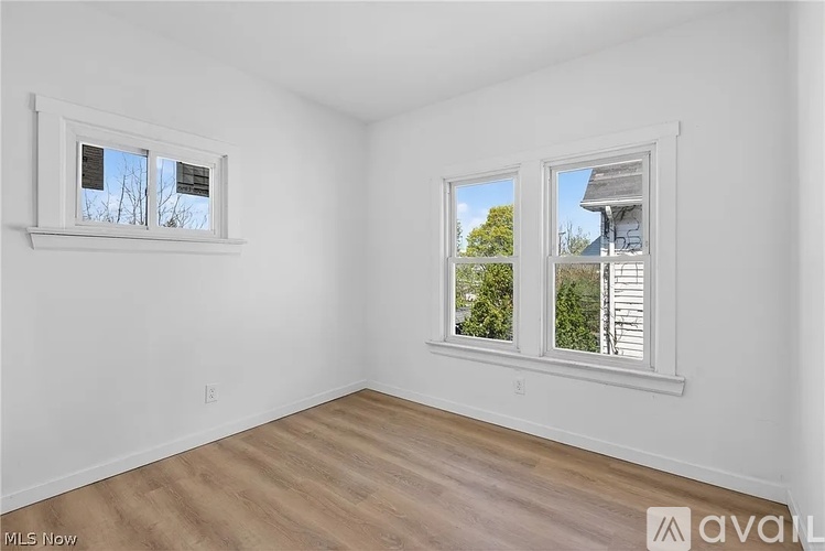 A room with two windows and wooden flooring is available on the market.