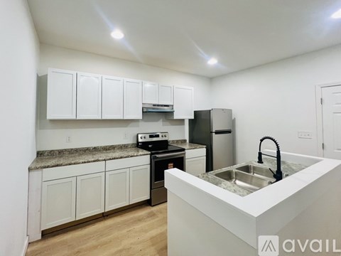 A kitchen with white cabinets and a granite countertop.