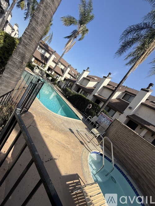 A pool surrounded by palm trees and apartment buildings.