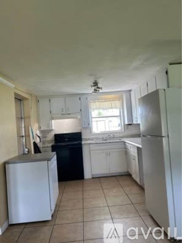 A kitchen with white cabinets and a black dishwasher.